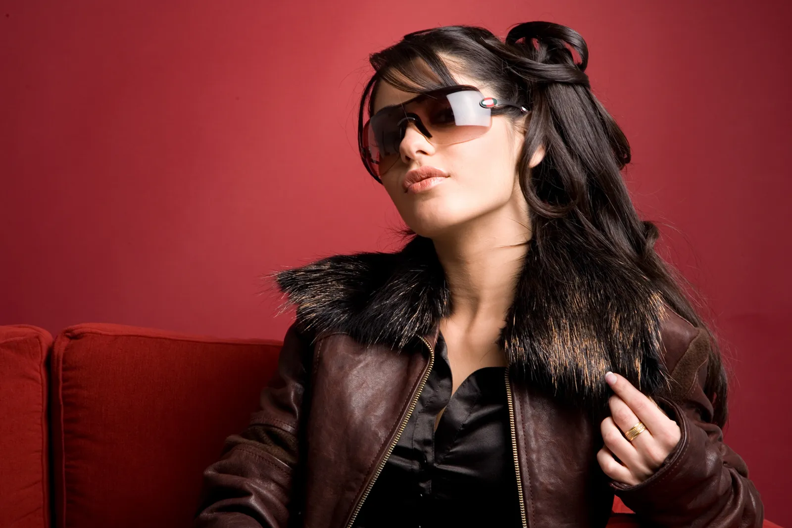 Two-page magazine spread pairing a woman in a floral headscarf and round sunglasses with a crouching figure in black cat-eye sunglasses and feathered wings.